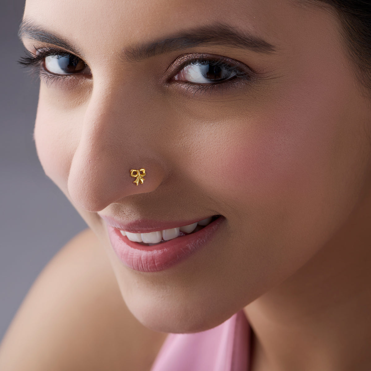 Woman wearing a bow-shaped gold nose pin