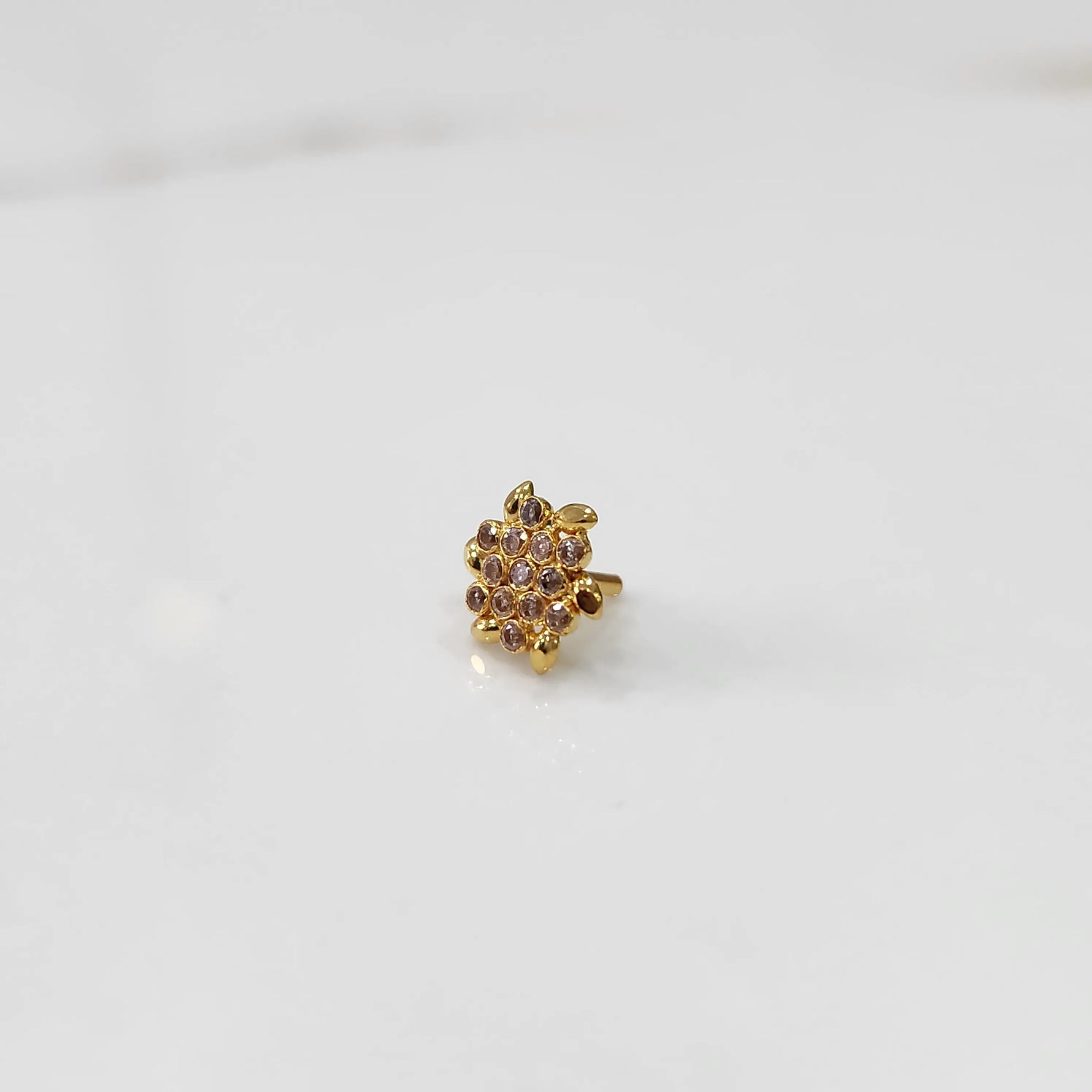 Gold statement ring with brown and clear gemstones in dense cluster design