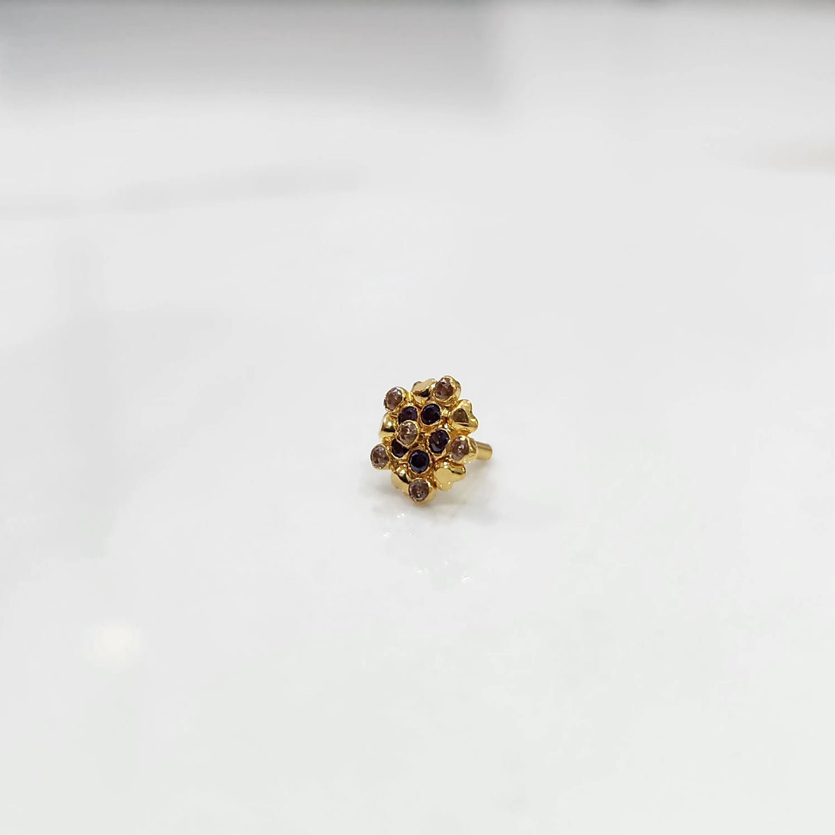 Gold statement ring with brown and purple gemstones in textured cluster design