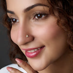 Woman wearing a butterfly-shaped gold nose pin