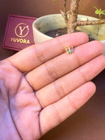 Colorful enamel butterfly-shaped gold nose pin held in hand, Yuvora jewelry box in background