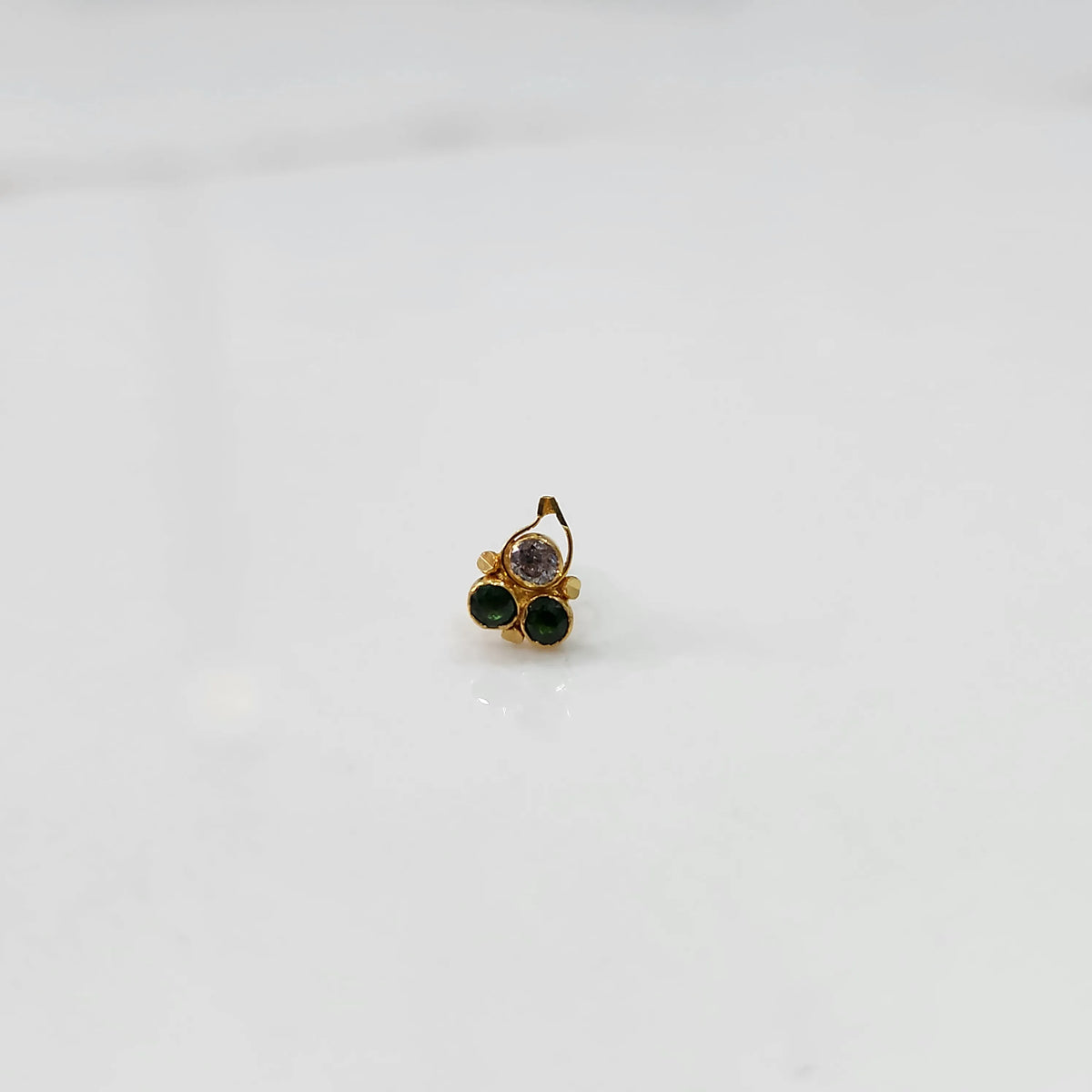 Gold nose pin with clear and green stones, product shot