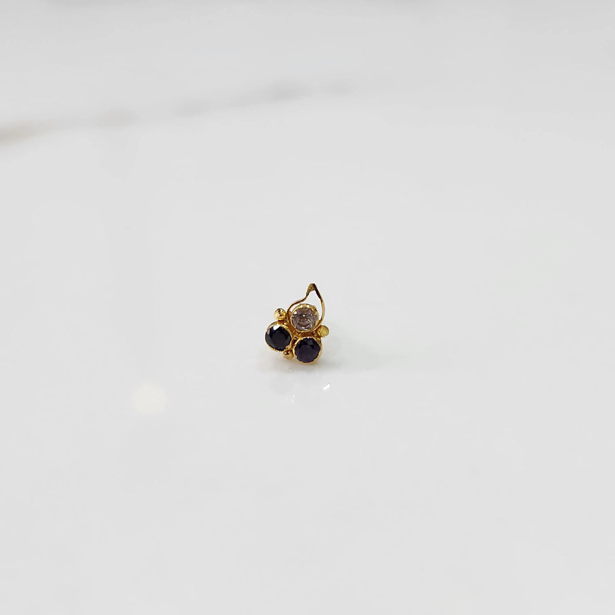 Gold statement ring with clear and purple gemstones in cluster leaf design