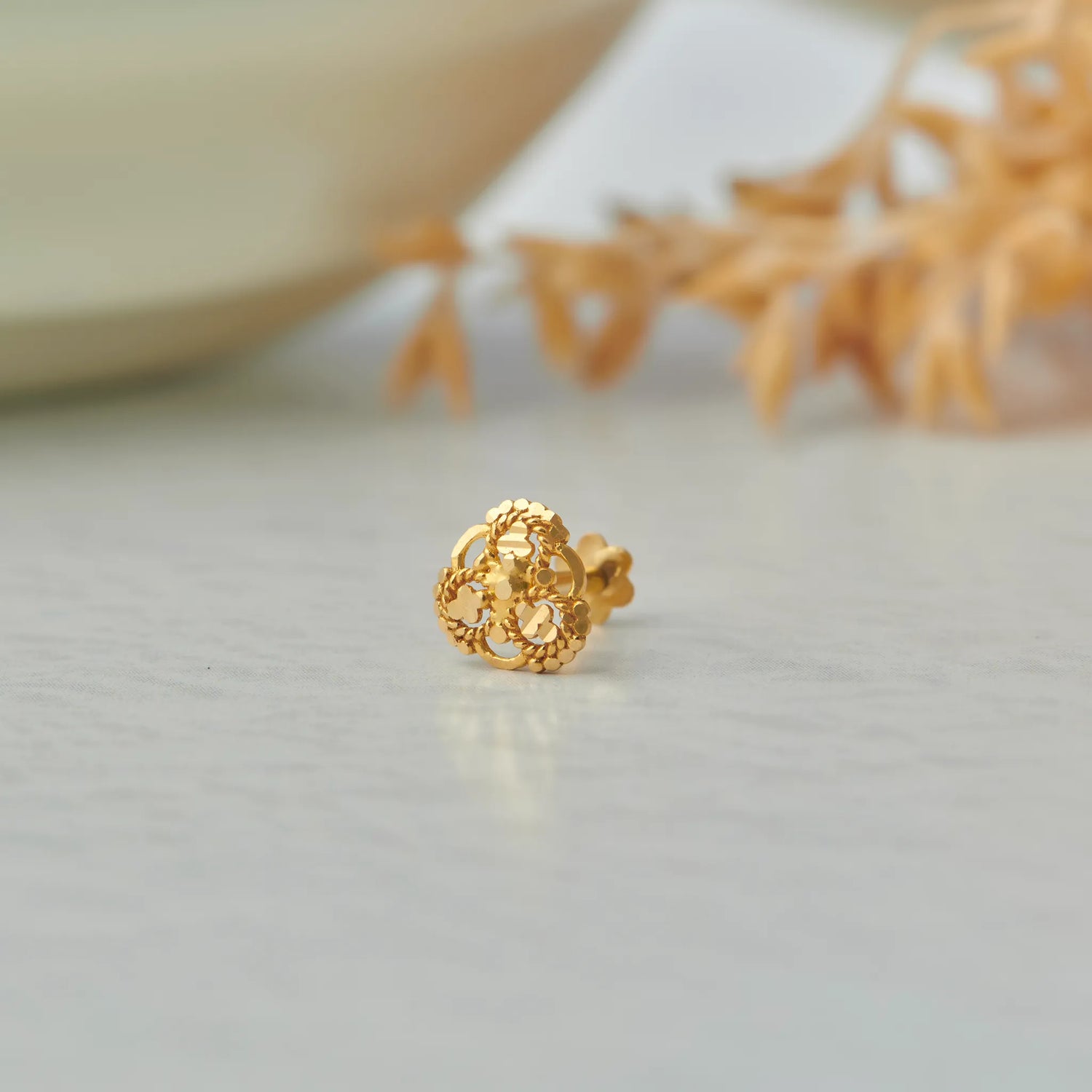 Gold stud earring with clover-shaped lattice design