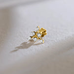 Product shot of an 18k gold stud with a multi-diamond flower-branch design