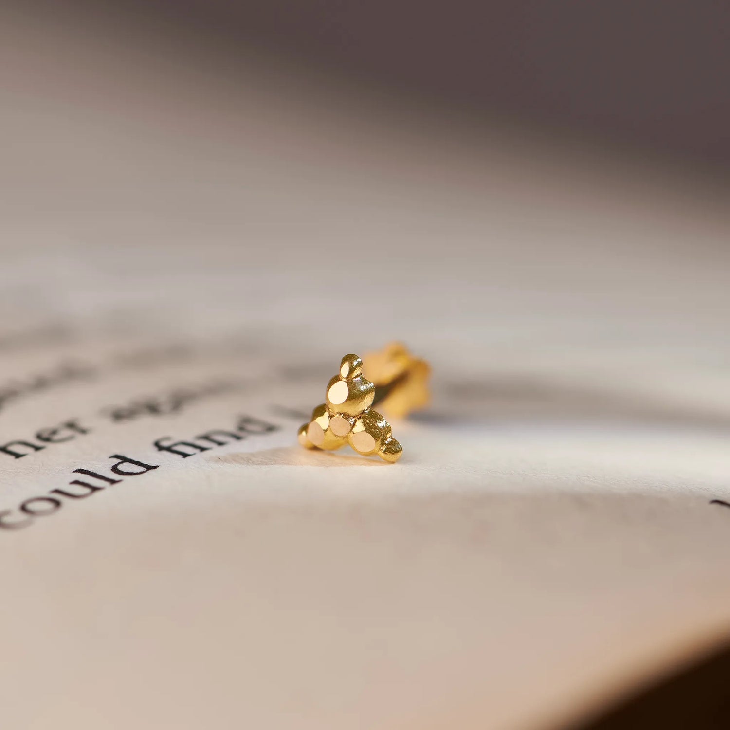 Gold cluster stud earring with stacked flat discs, close-up