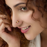 Woman wearing dense multicolor floral gold nose pin