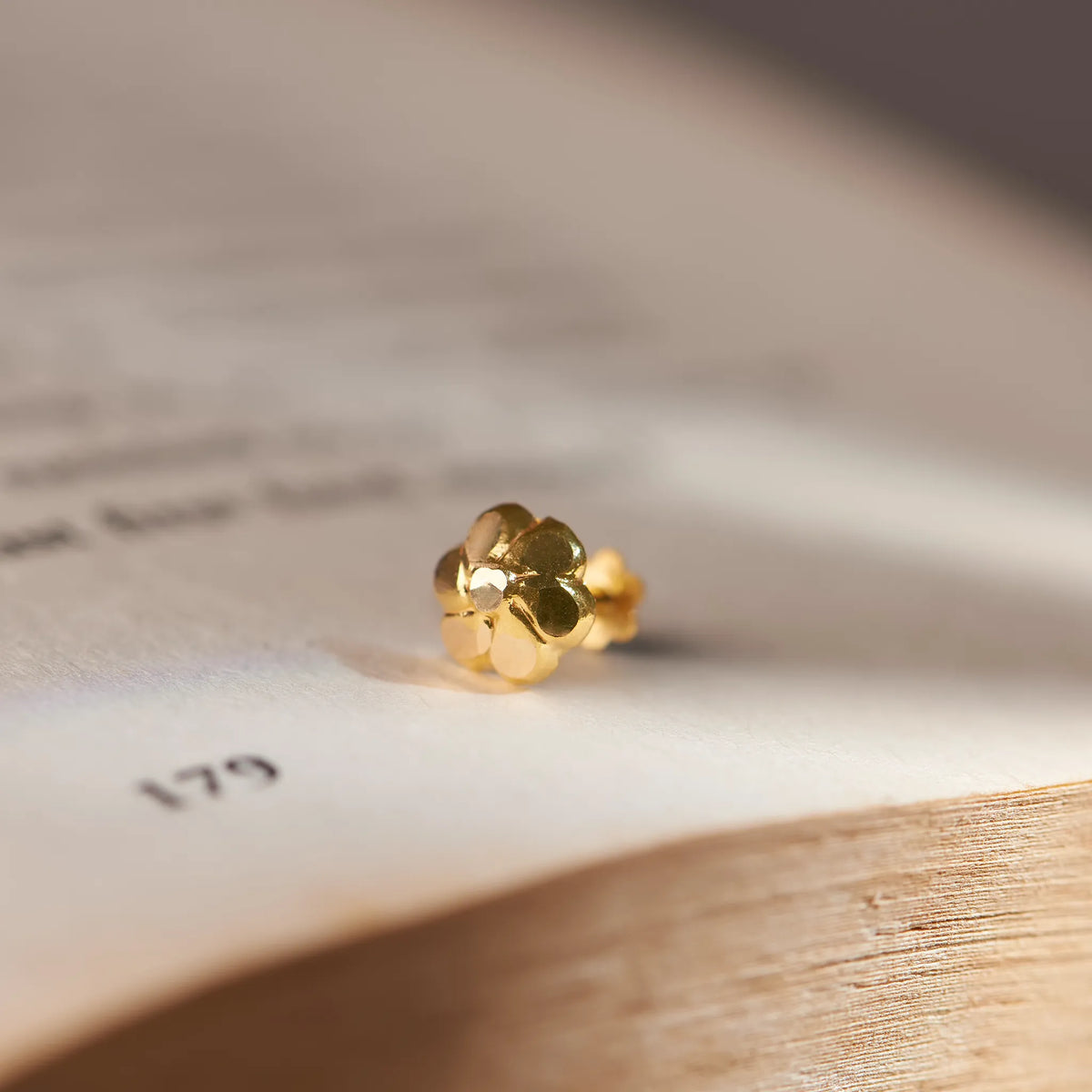 Gold textured flower stud earring, alternate angle