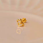 Gold double interlocked heart nose stud on beige background