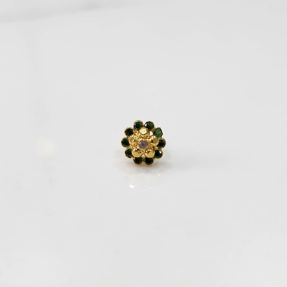 Front view of gold floral ring with green gemstone petals