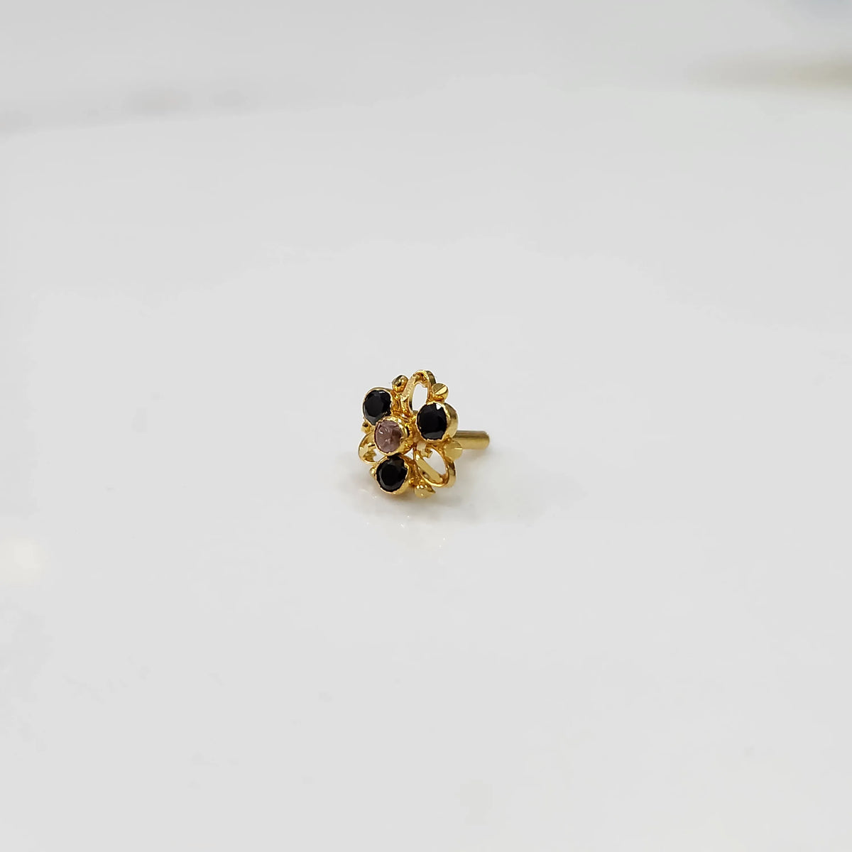 Gold filigree ring with black and clear gemstones