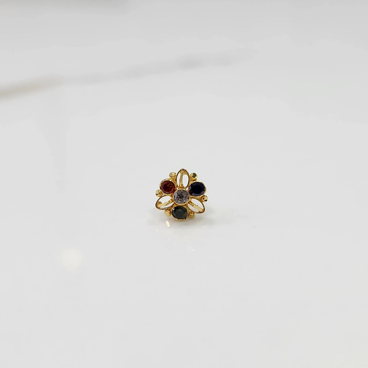 Top view of gold filigree ring with four multicolor oval gemstones