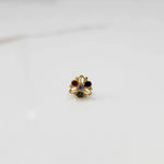 Top view of gold filigree ring with four multicolor oval gemstones