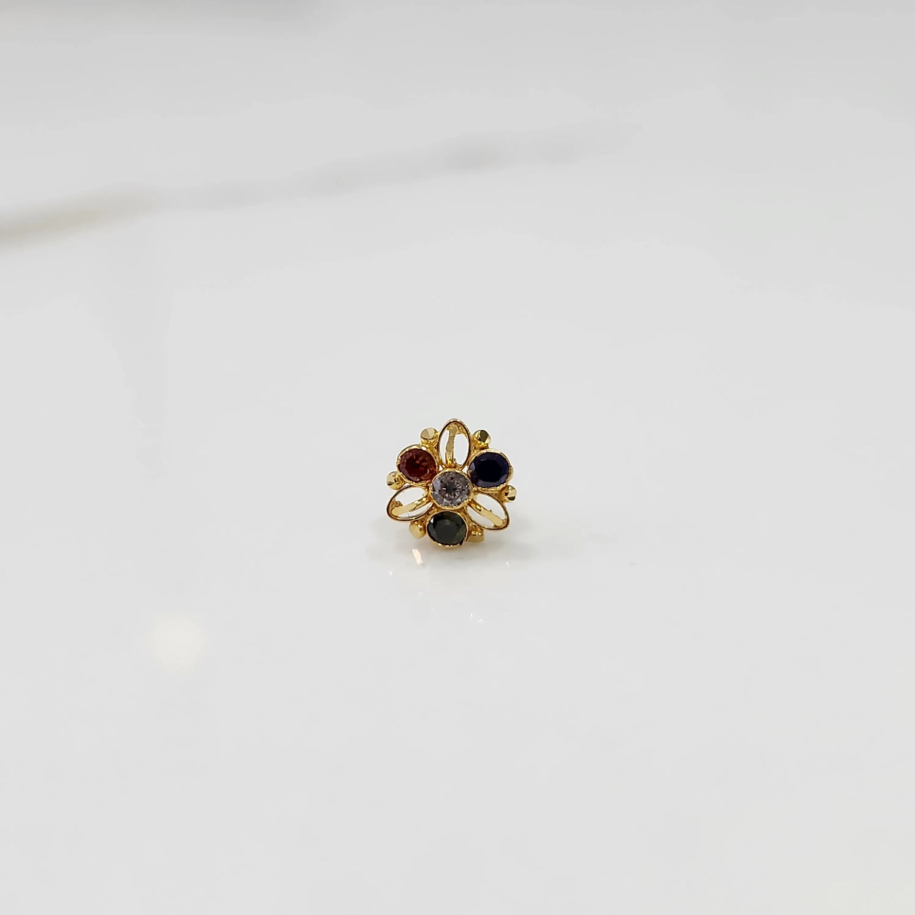 Top view of gold filigree ring with four multicolor oval gemstones