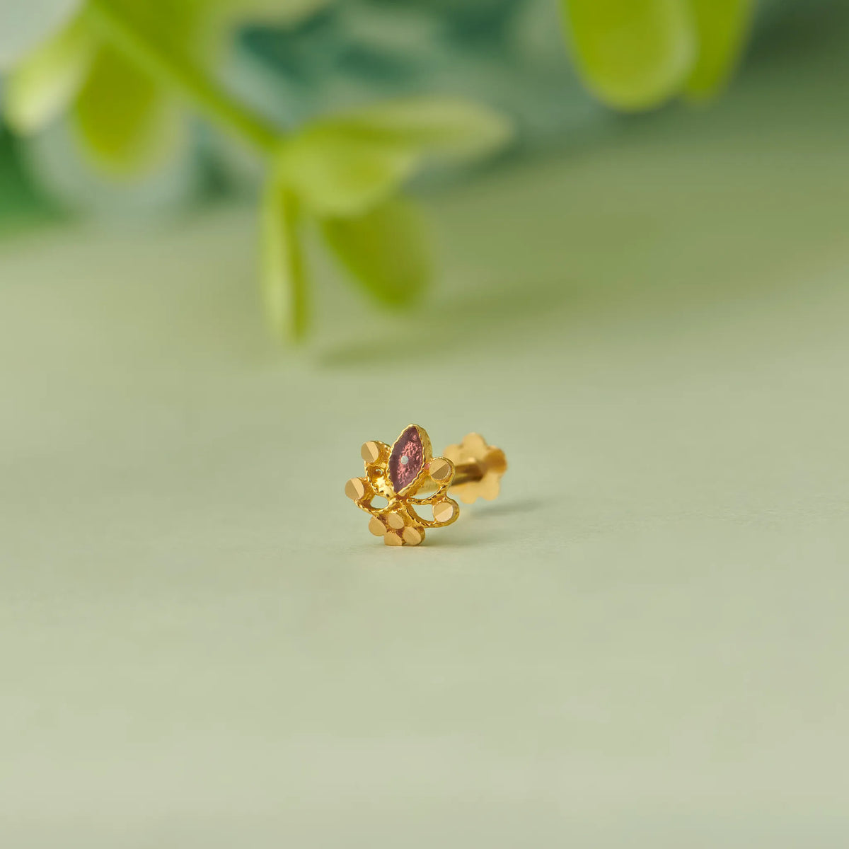 Gold floral stud earring with marquise-cut purple gemstone
