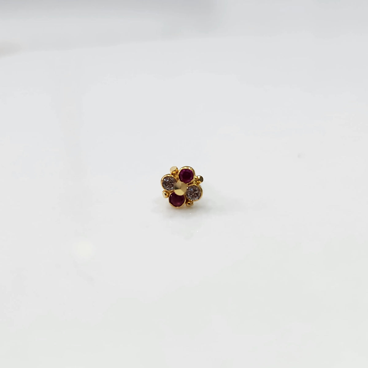 Gold floral jewelry stud with red and clear stones
