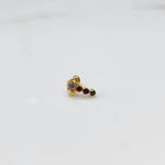 Front view of gold nose pin with multicolor floral head and stone trail