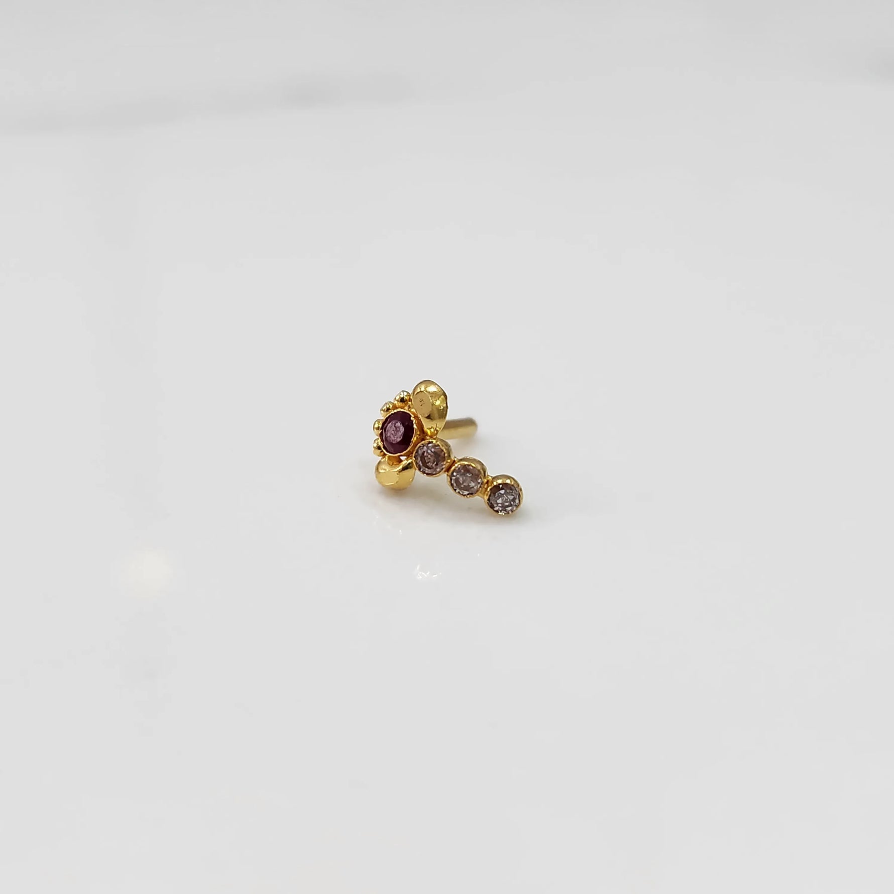 Gold nose pin with red floral head and clear stone trail