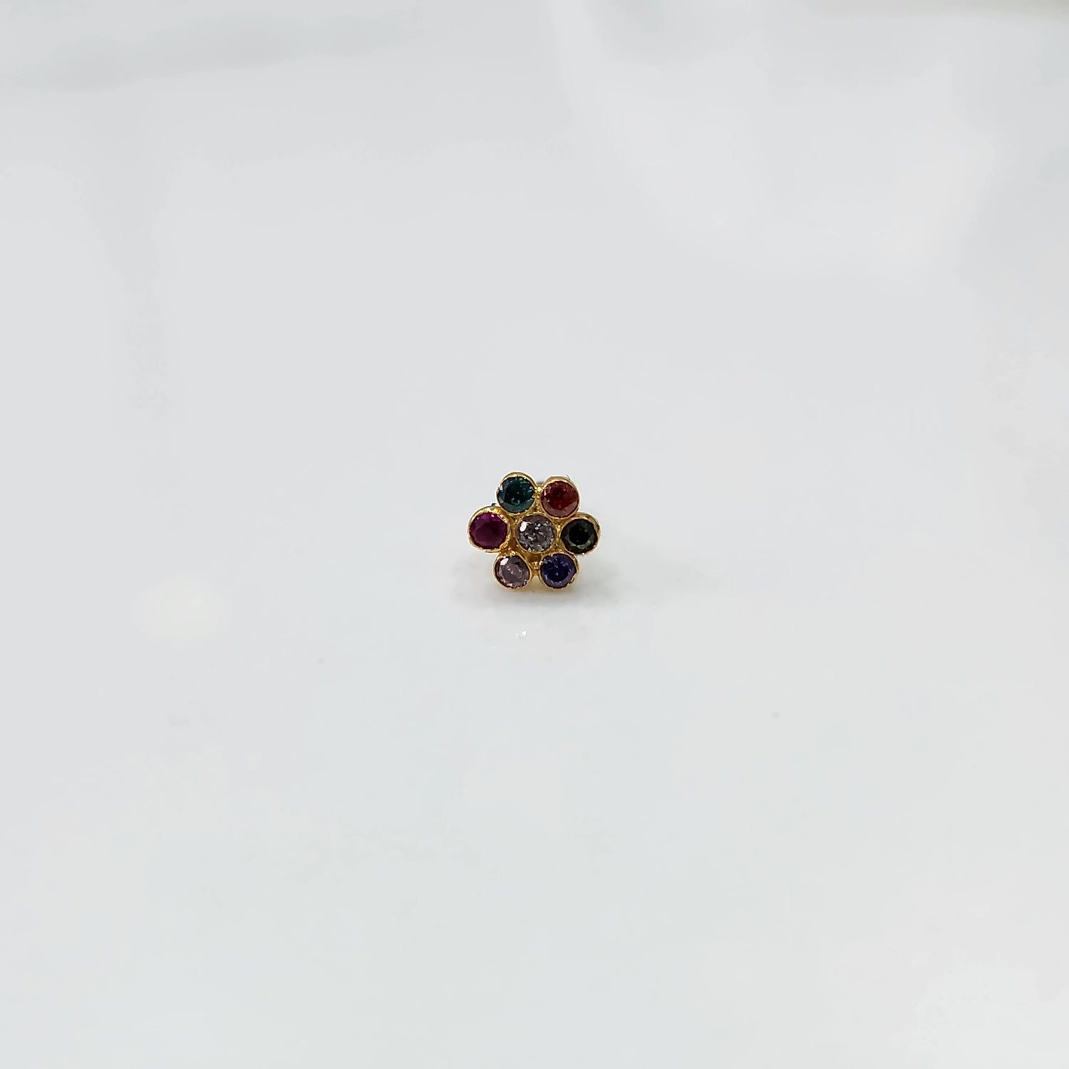 Woman wearing nose pin design gold with floral stone pattern close up