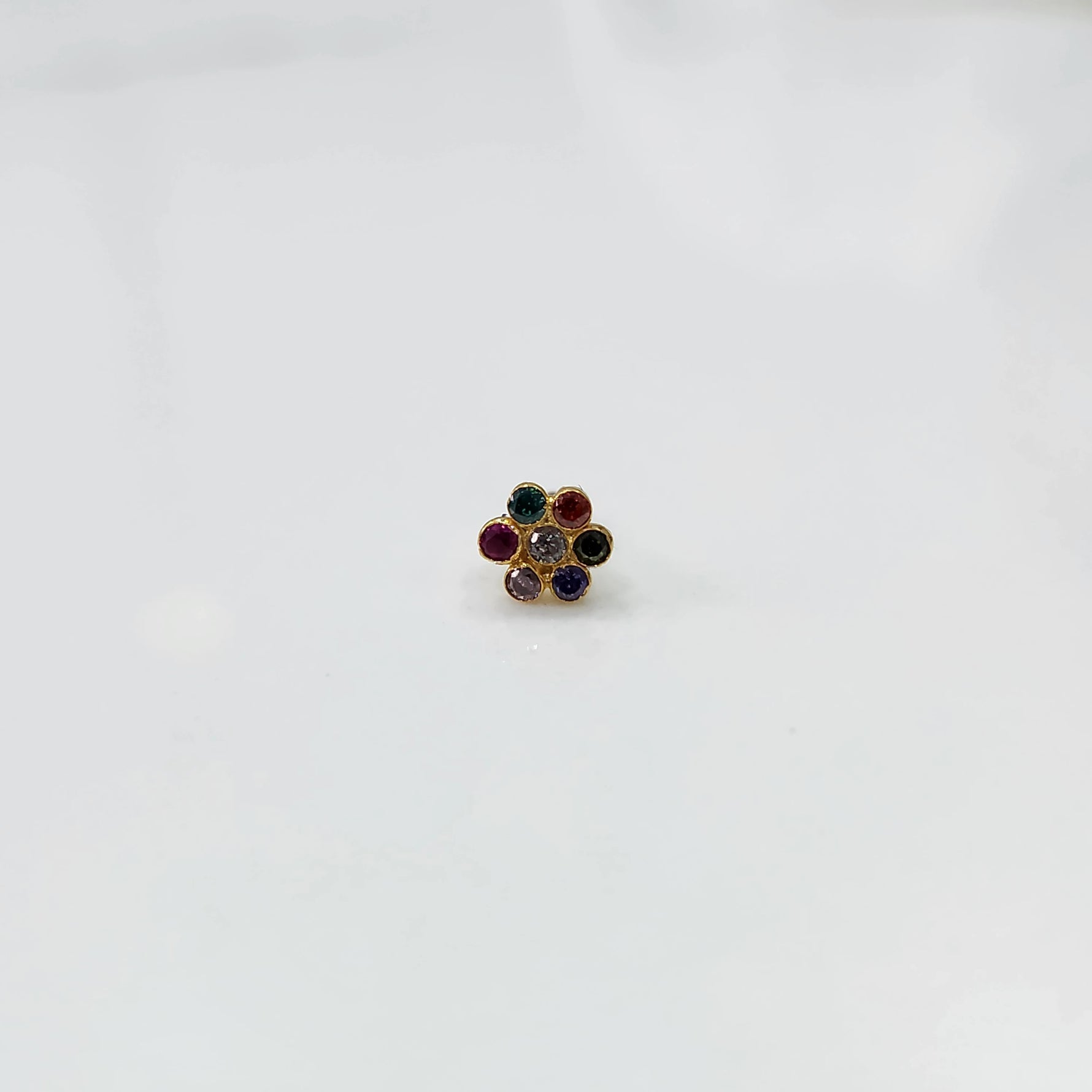 Woman wearing nose pin design gold with floral stone pattern close up