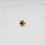 Gold ring with black center stone and pink round petal stones