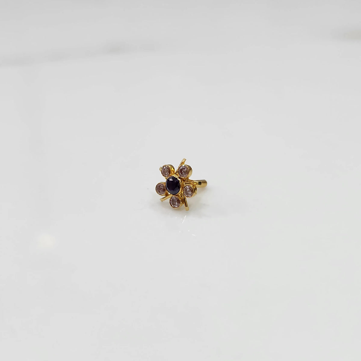 Gold ring with black center stone and pink round petal stones