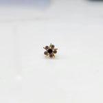 Top view of gold ring with black center stone and prong-set petals