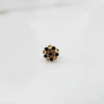 Gold flower ring with black and clear gemstones in halo setting