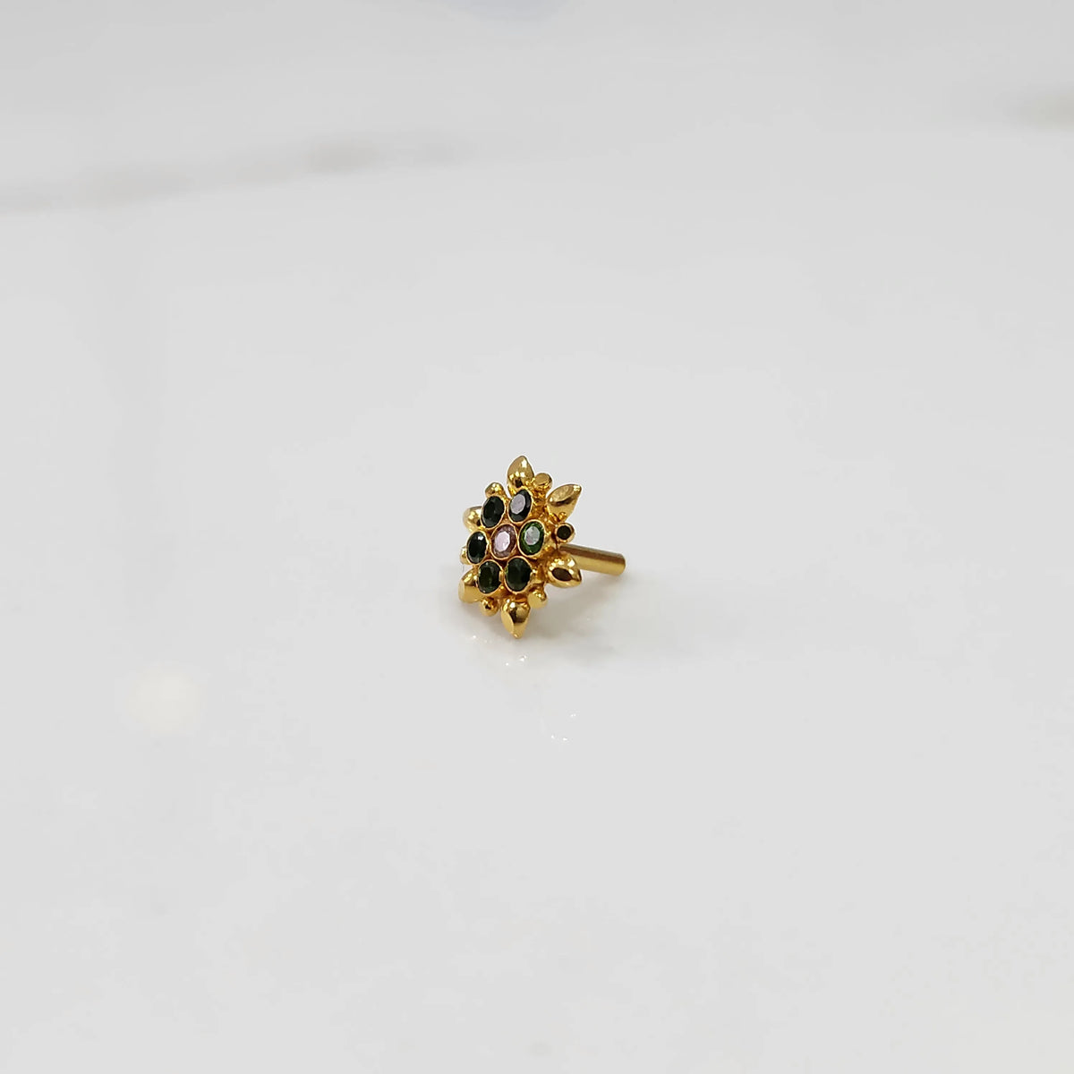Side view of gold flower ring with black and multicolor gemstones
