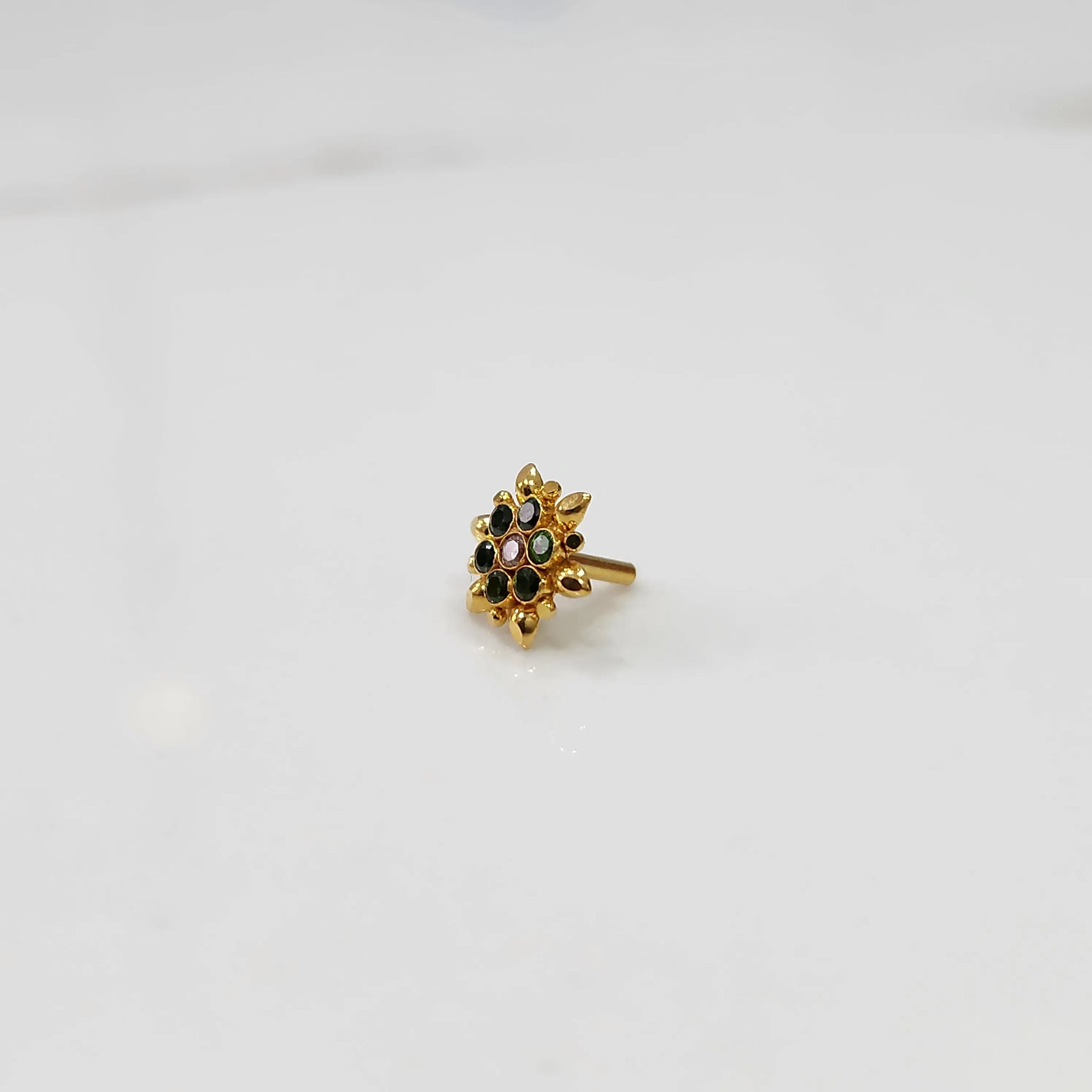 Side view of gold flower ring with black and multicolor gemstones