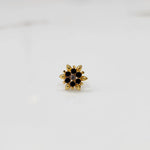 Gold flower ring with black and purple gemstones, front view