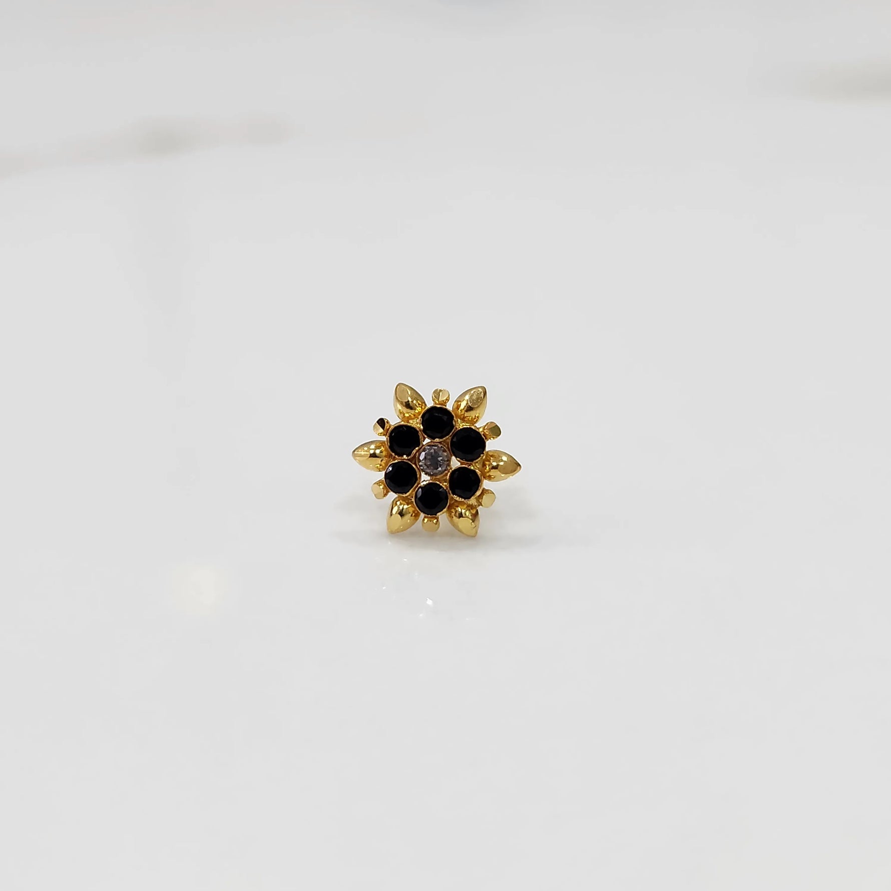 Gold flower ring with black and purple gemstones, front view