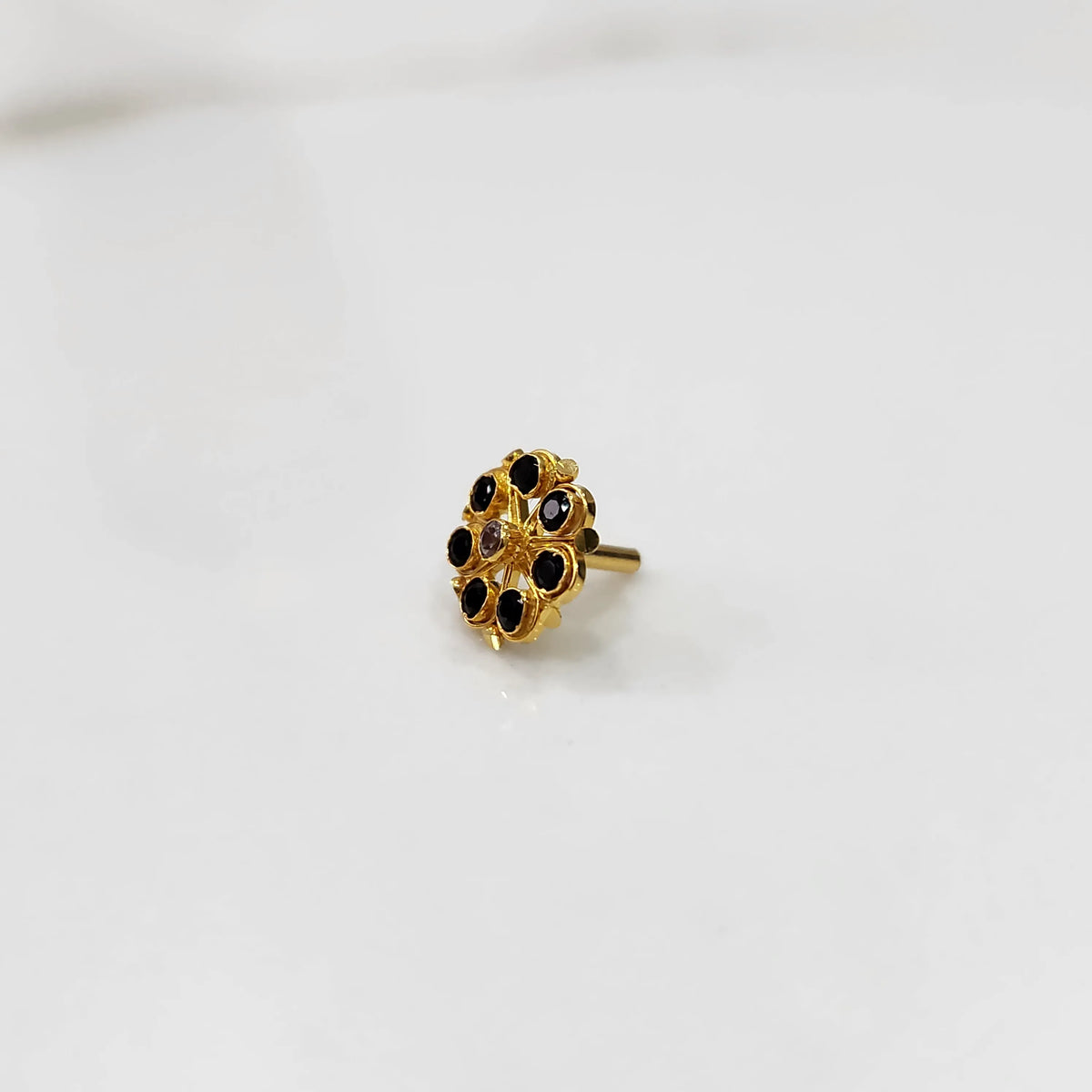 Gold flower ring with black gemstones, front view