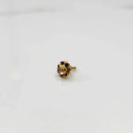 Side view of gold flower ring with blue and purple gemstones