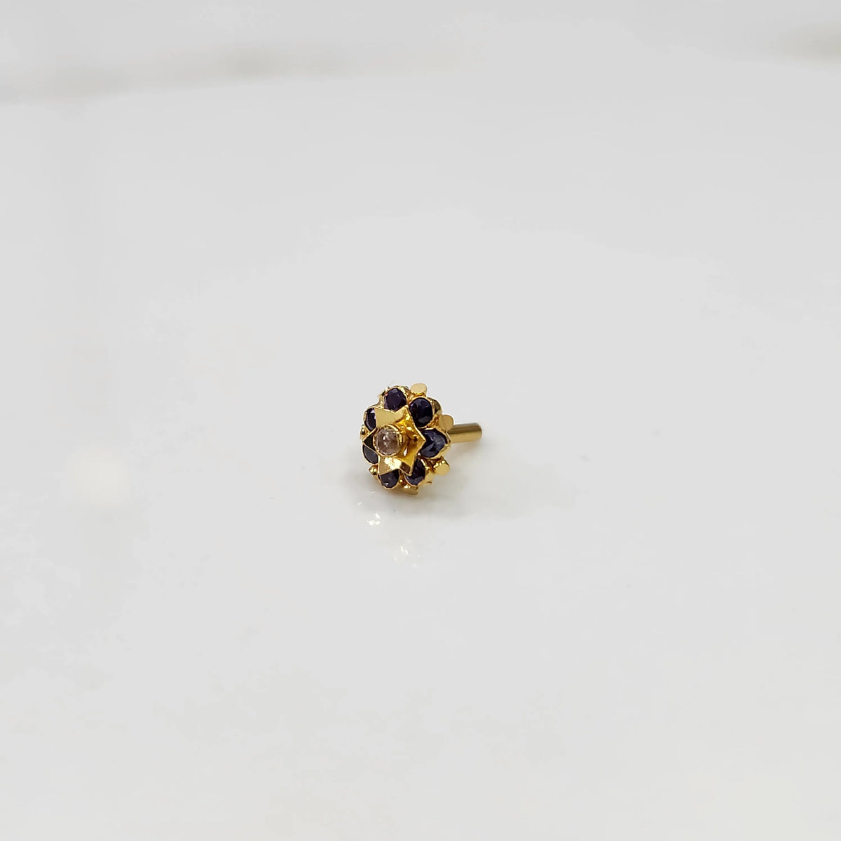 Side view of gold flower ring with blue and purple gemstones