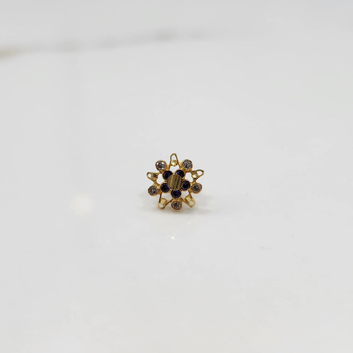 Gold flower ring with blue center stones and surrounding gemstones