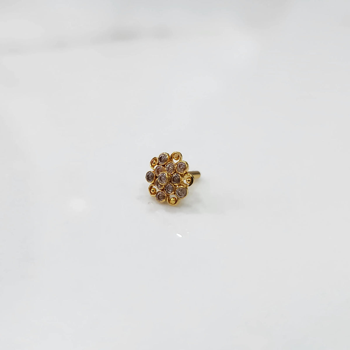 Gold flower ring with clear gemstones in halo setting
