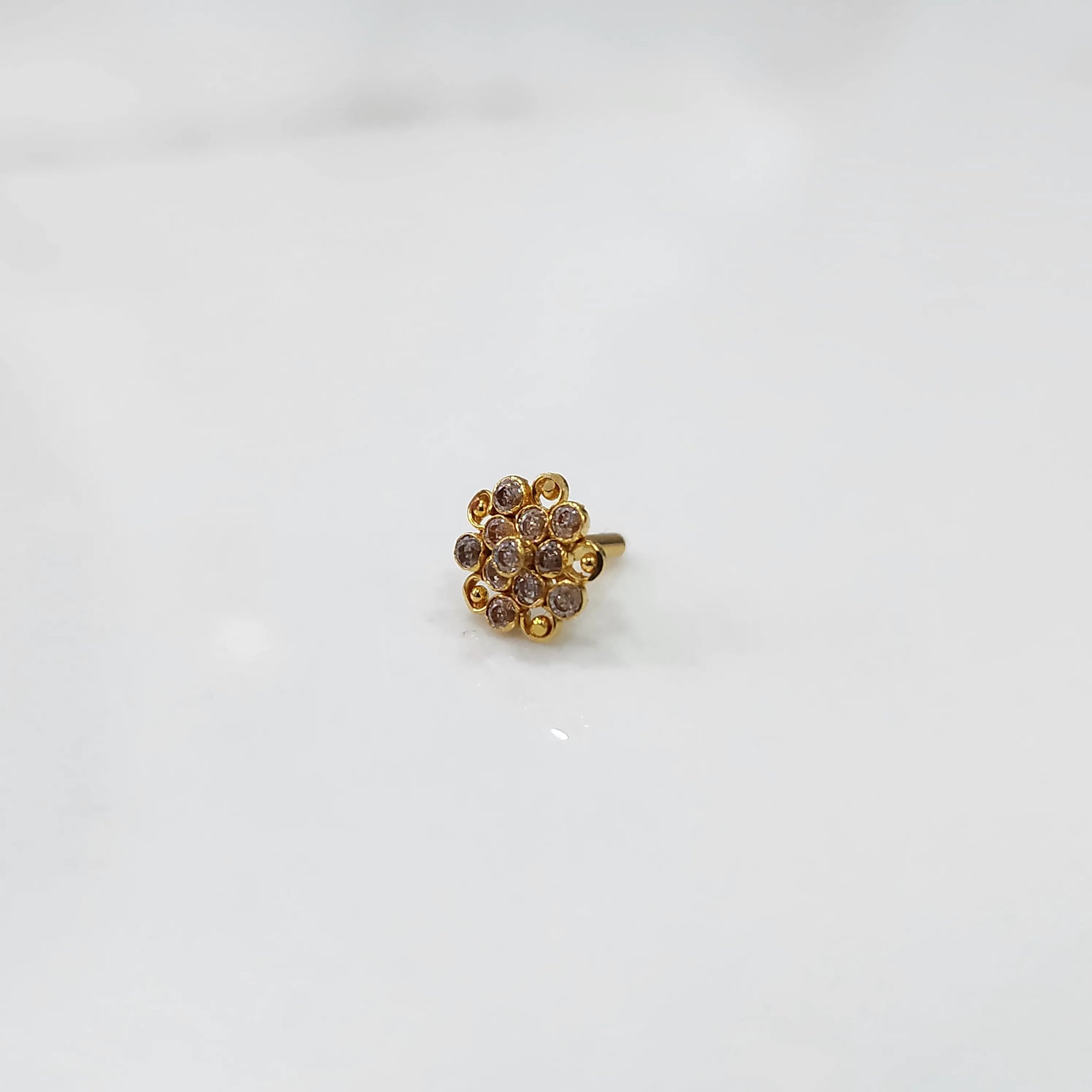 Gold flower ring with clear gemstones in halo setting