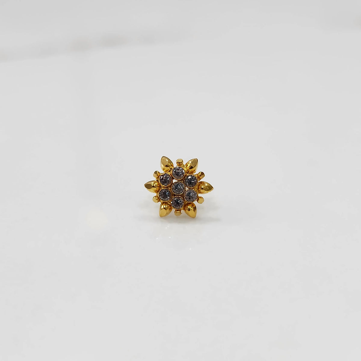 Gold flower ring with clear gemstones, front view