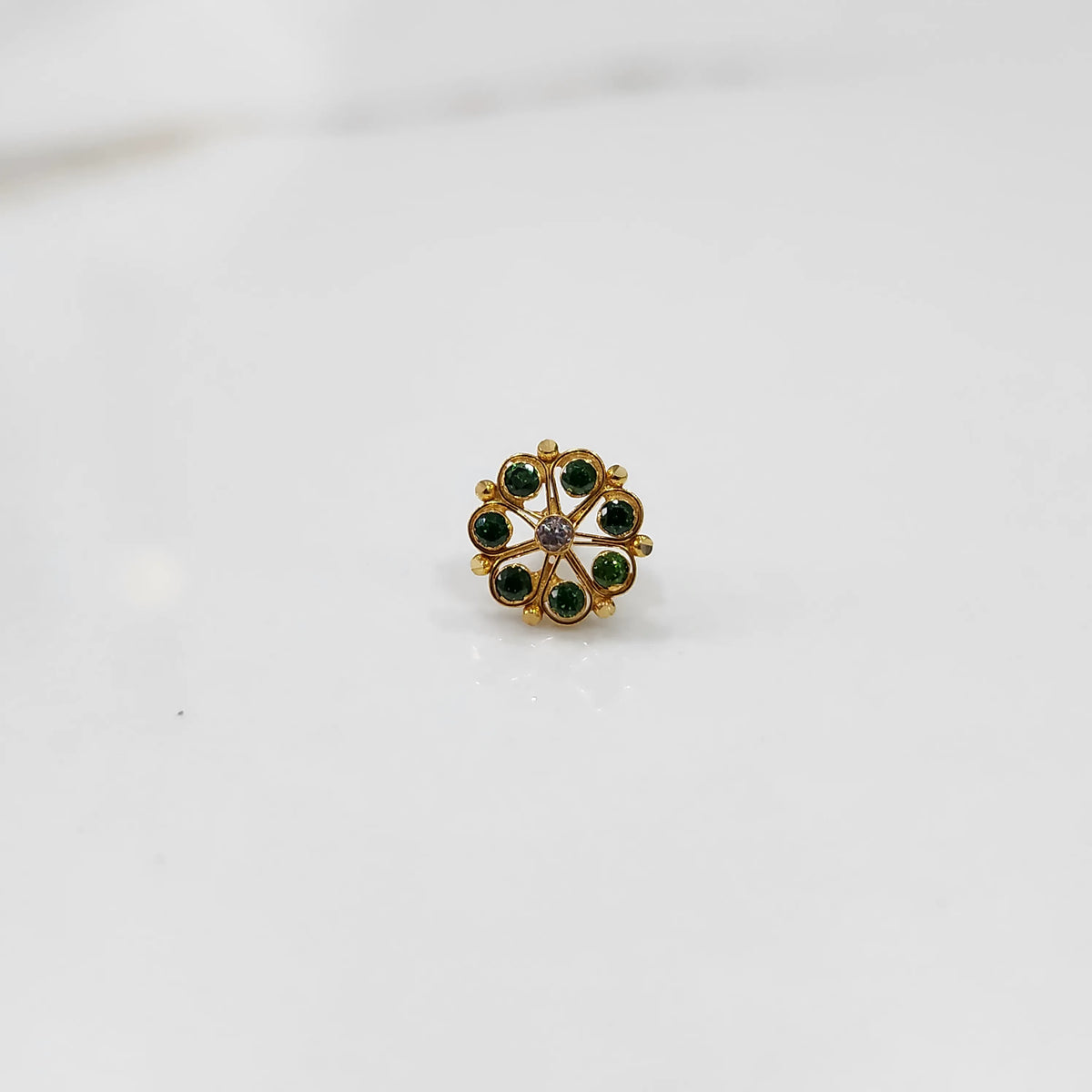 Antique-style gold ring featuring emerald-toned stones, front-facing shot