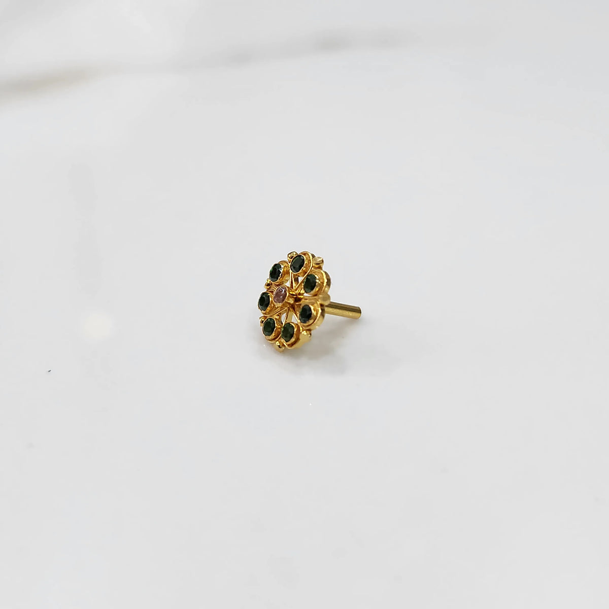 Gold flower ring with green gemstones, front view
