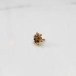 Angled view of gold flower ring with multicolor gemstones
