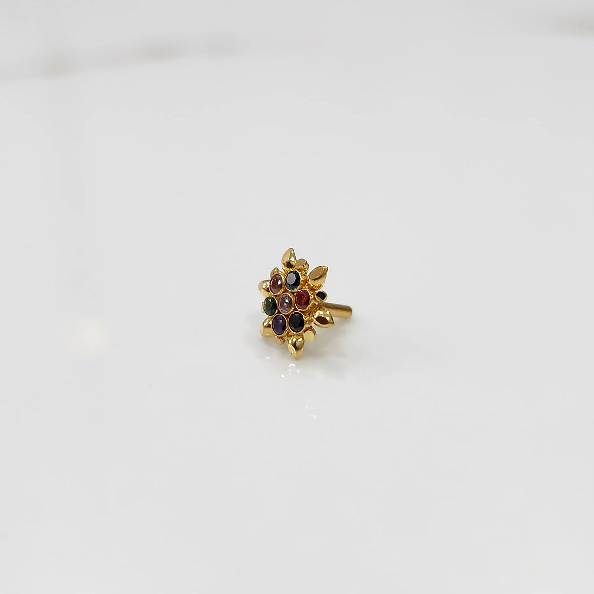 Angled view of gold flower ring with multicolor gemstones