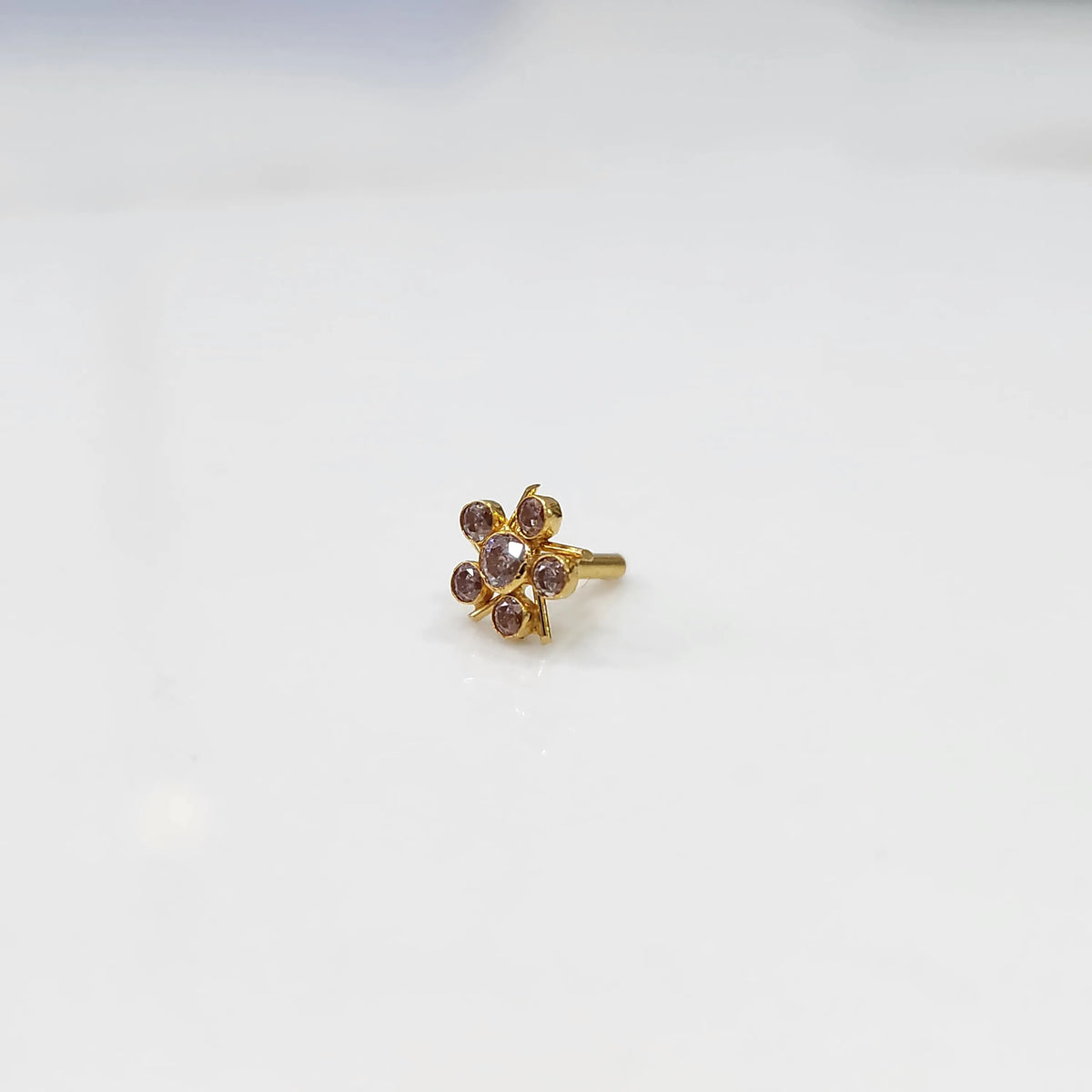 Gold ring with pink round stones in a five-petal flower design