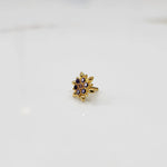 Gold flower ring with purple and black gemstones, front view
