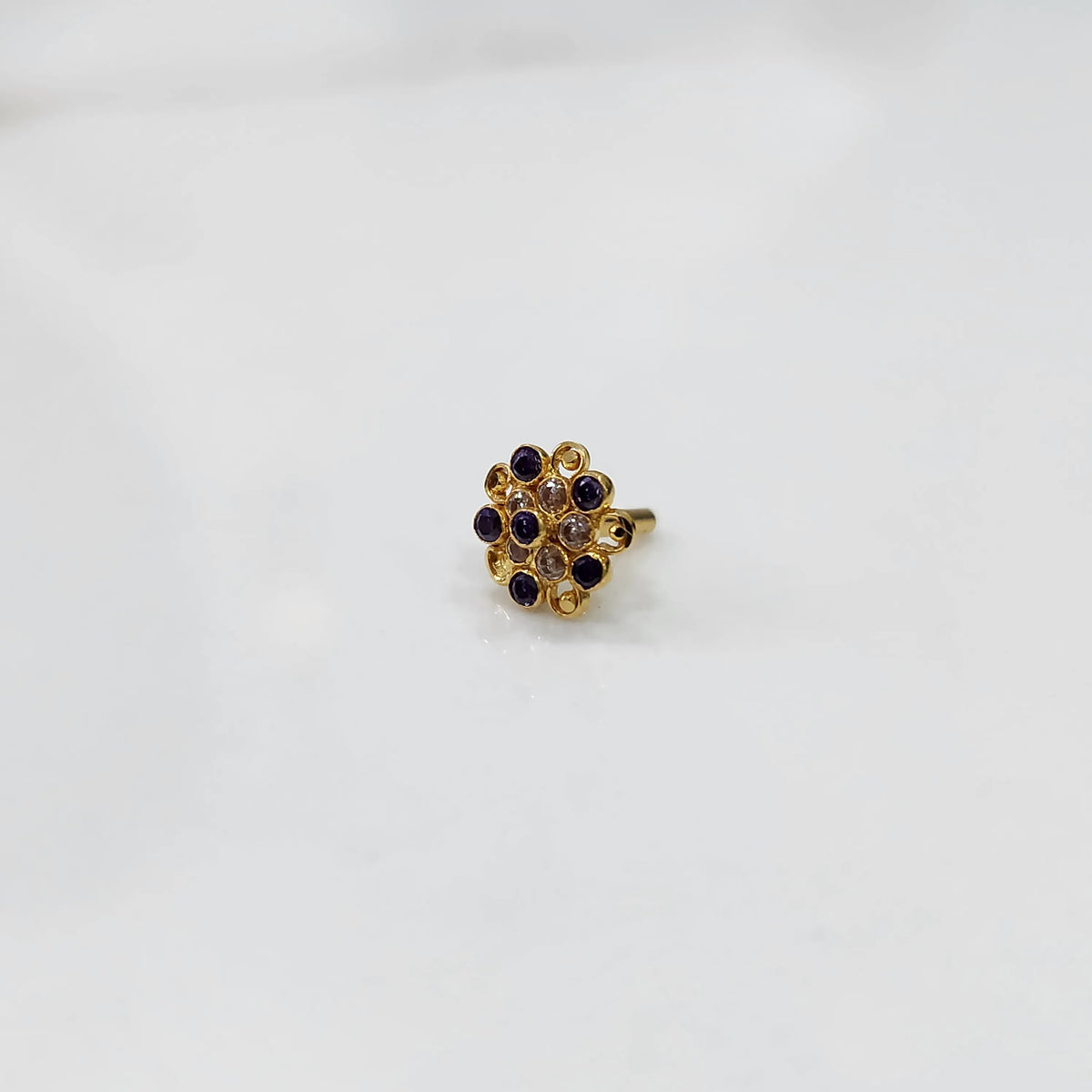 Antique-style gold ring featuring amethyst-toned stones in halo design