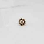 Gold flower ring with purple and clear gemstones, front view