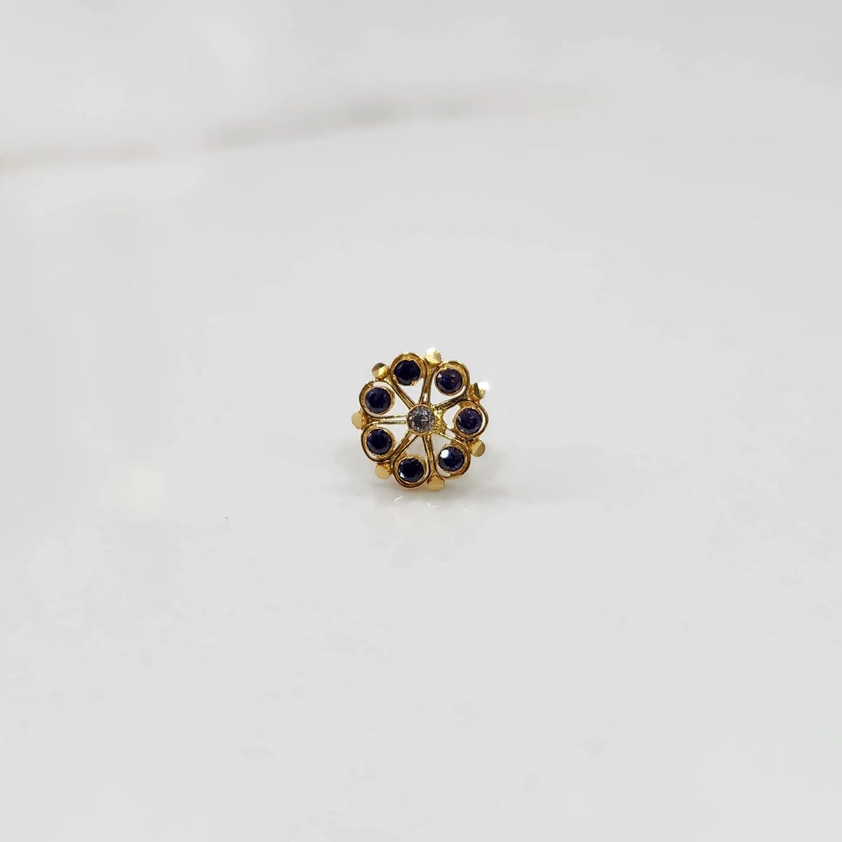 Gold flower ring with purple and clear gemstones, front view