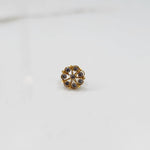 Front view of gold ring with purple gemstone petals