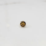Gold flower ring with purple gemstones and gold star center